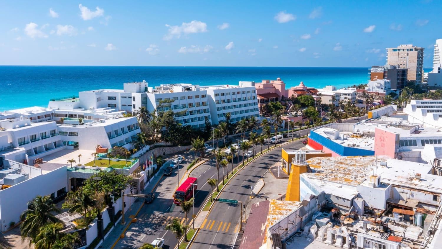 Carretera costera de Cancún bordeada de palmeras junto al mar Caribe
